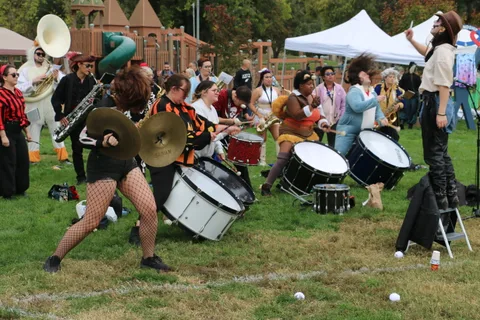 The drum line performs energetically in skeleton makeup and costume.