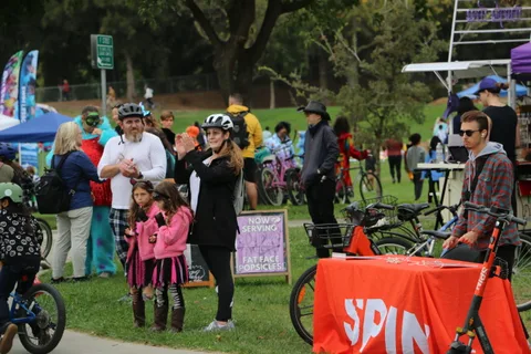 A busy crowd scene near a Spin bike-share banner.