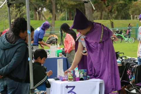 Costumed volunteers serve treats to a boy at the festival booth.