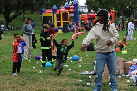 Families play a ball game near an inflatable bounce castle at the festival.