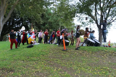 A costumed crowd gathers near the lake in the distance.