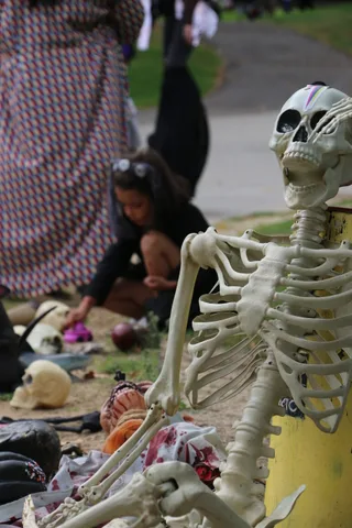 A hand reaches for candy near skeleton decorations.