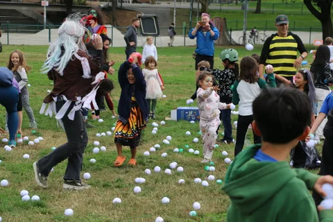 A dancer in a torn dress and white wig moves through a dynamic zombie-inspired pose.
