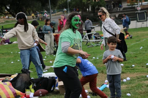 A woman in zombie face paint stands near another festival-goer during the game.