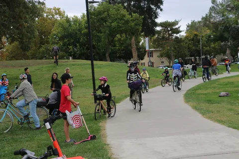A wide, distant view of riders passing by, including a skeleton costume.
