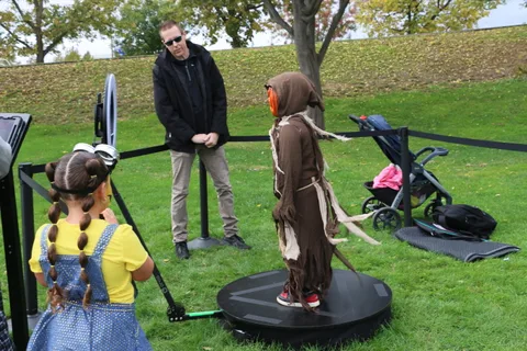 Two children in costume pose on the 360 photo booth platforms.
