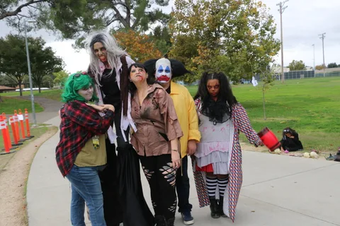 Costumed performers walk together along the festival path.
