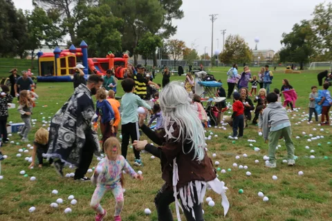 Costumed kids reach for balls in a blur of motion.