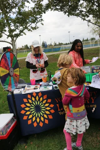 A girl looks at a flyer handed to her by a staff member.