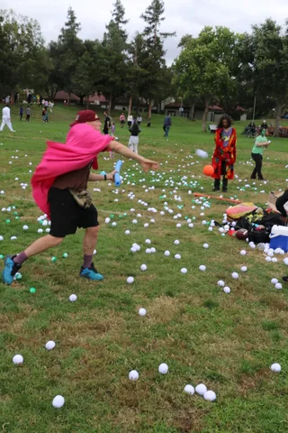A caped figure runs across the grass, cape trailing in motion blur.