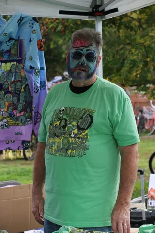 A close view of a green festival T-shirt design on a man's torso.
