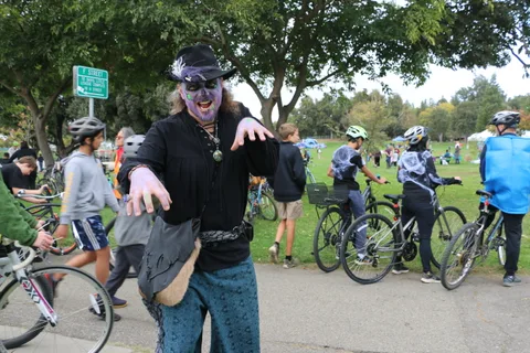 A man in zombie face paint reaches toward the camera with a dramatic expression.