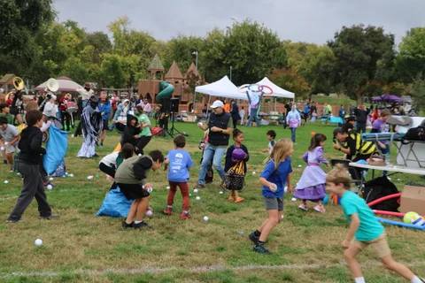 Kids scatter across the grass during the ball-toss game.