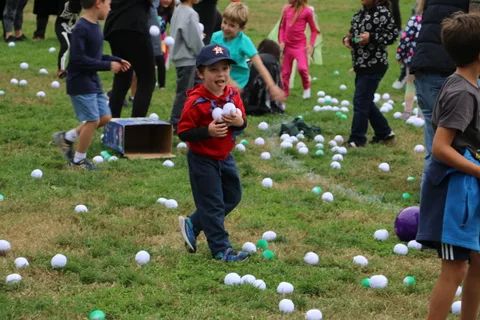 A boy in a red shirt plays near a friend in teal amid the ball-toss game.