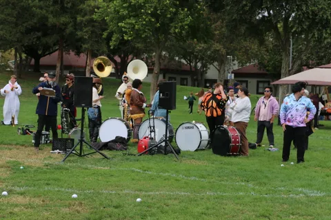 A tuba player leads the costumed brass band in performance.