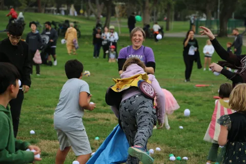 Two people in elaborate feathered costumes lean together in a blur of motion.
