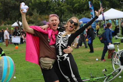A skeleton-costumed man and a woman laugh together at the festival.