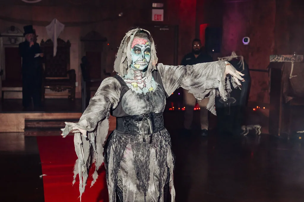 A guest in a tattered mummy costume reaches out on the red carpet at the Zombie Ball.