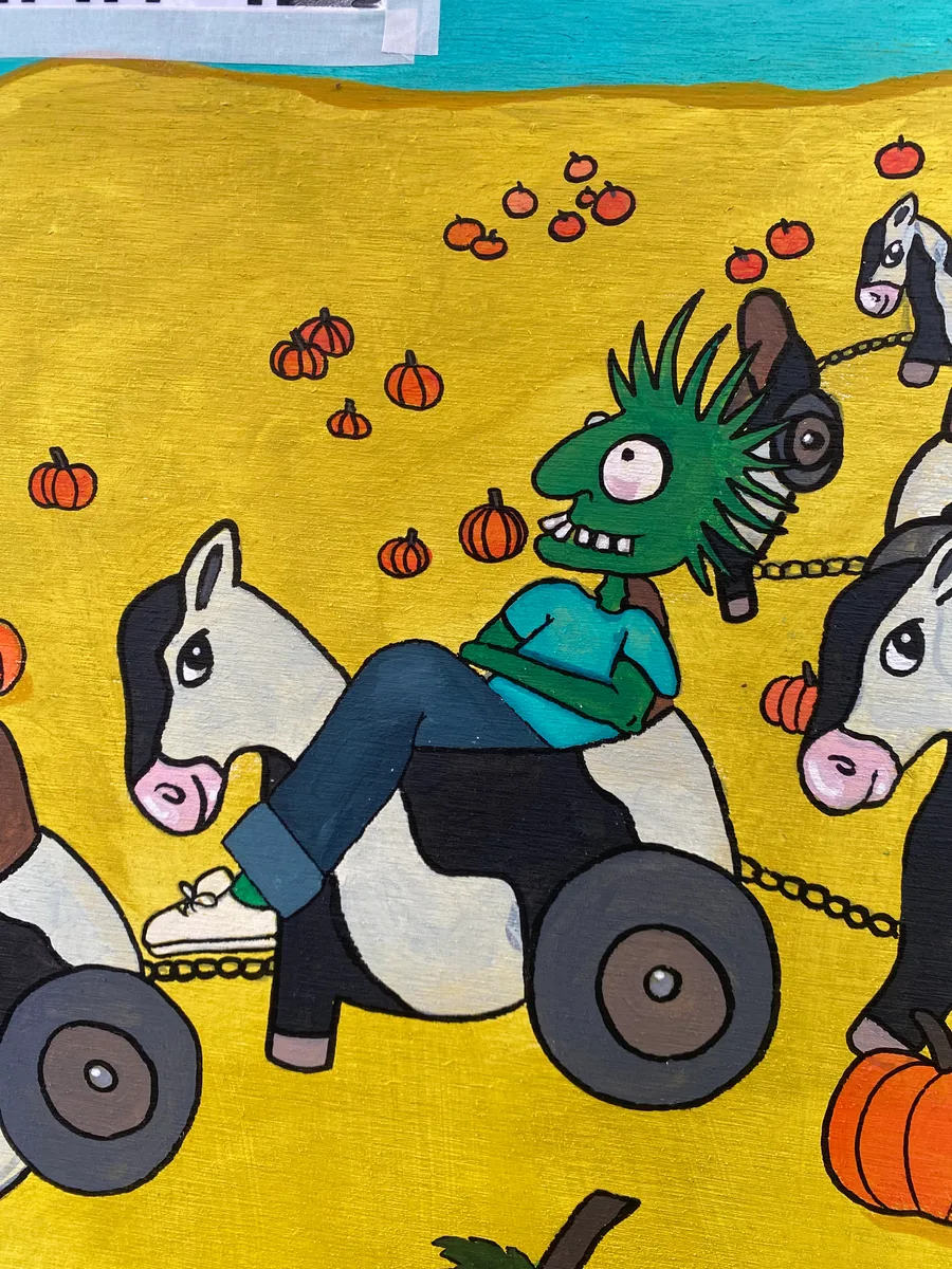 An illustration of a horse pulling a zombie character in a wheelchair-style cart among pumpkins.