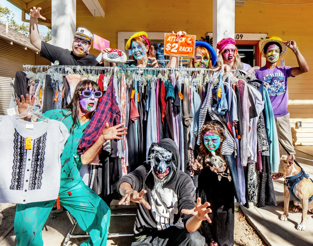 Costumed guests browse a clothing rack at the Boheme Clothing and Gifts sponsor shop.