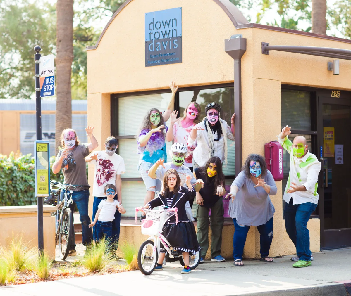 A costumed family poses in front of the Downtown Davis office.