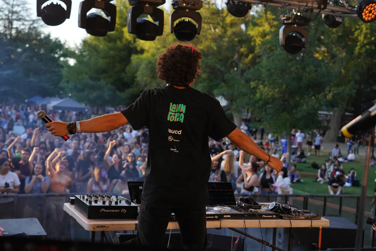 A DJ performs on stage above a crowd at the Zombie Ball.