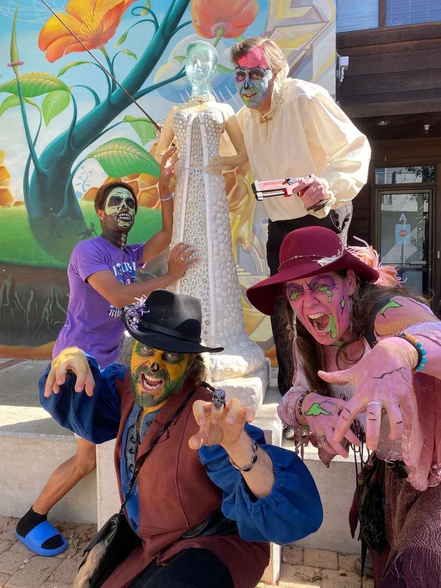 Two costumed guests pose beside a whimsical beanstalk backdrop.
