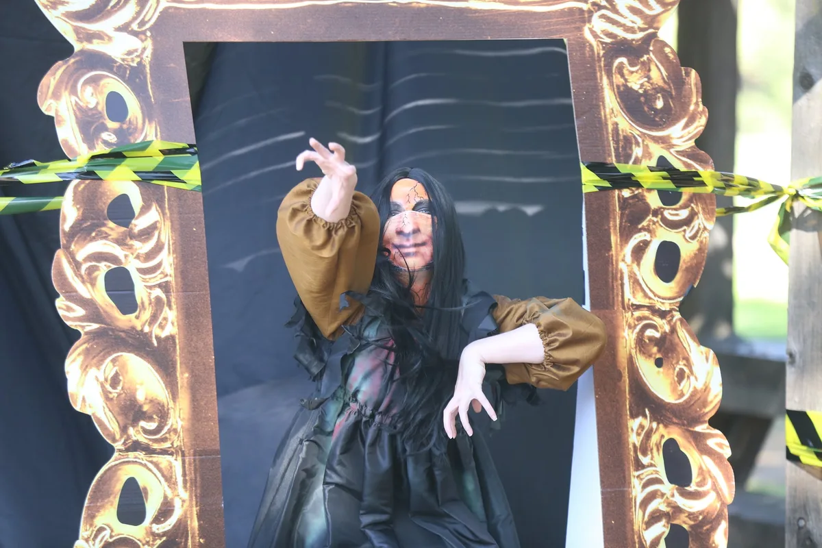 A decorated photo backdrop featuring a cutout zombie bride and groom figure.