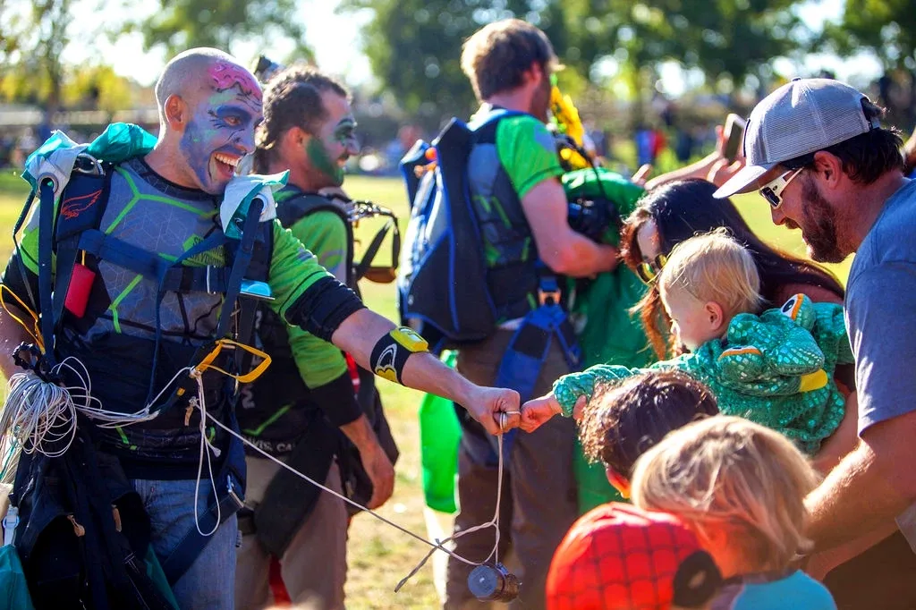 Two men in green zombie makeup pose outdoors.
