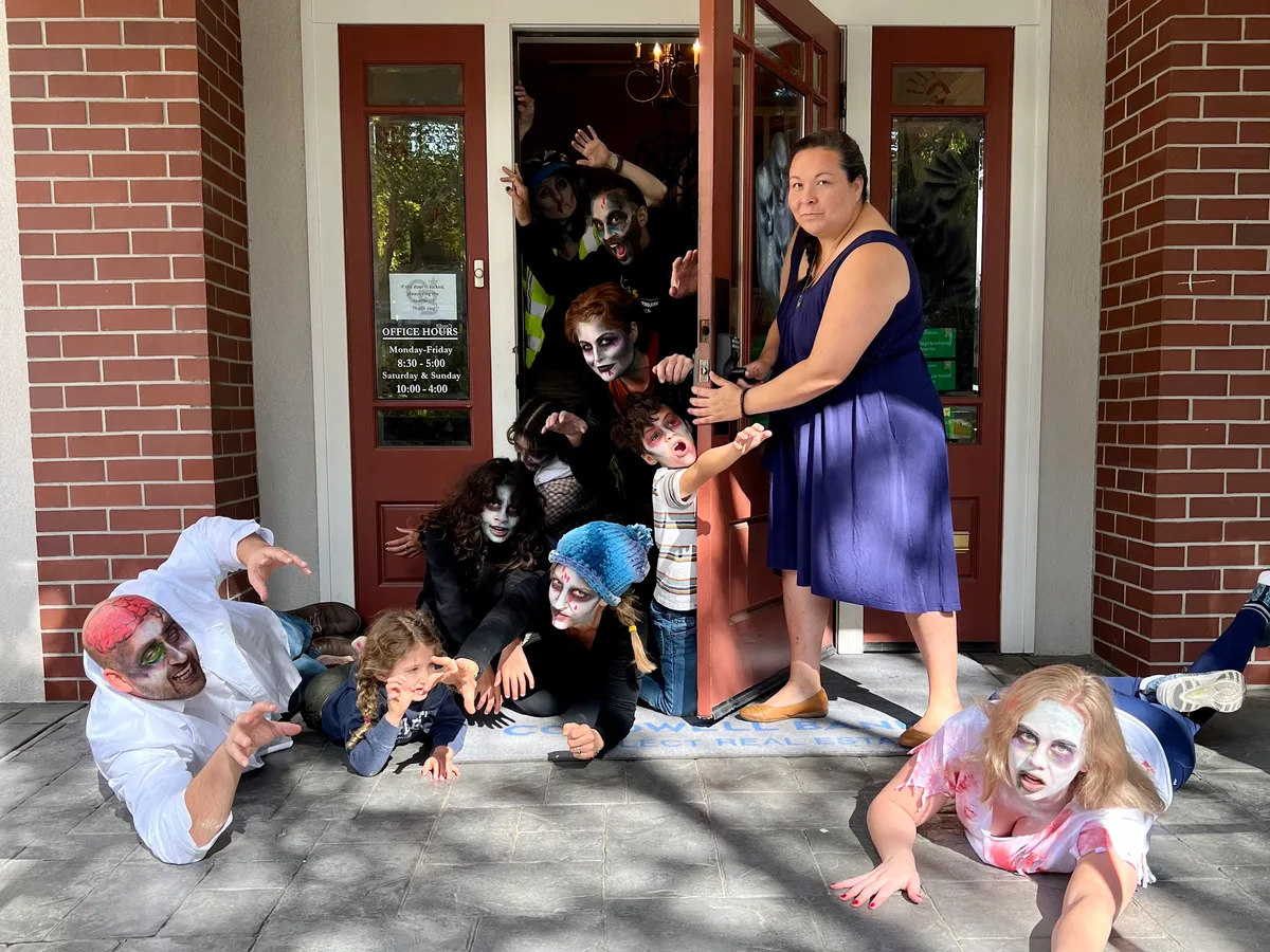 A family in monster masks poses in a brick doorway.