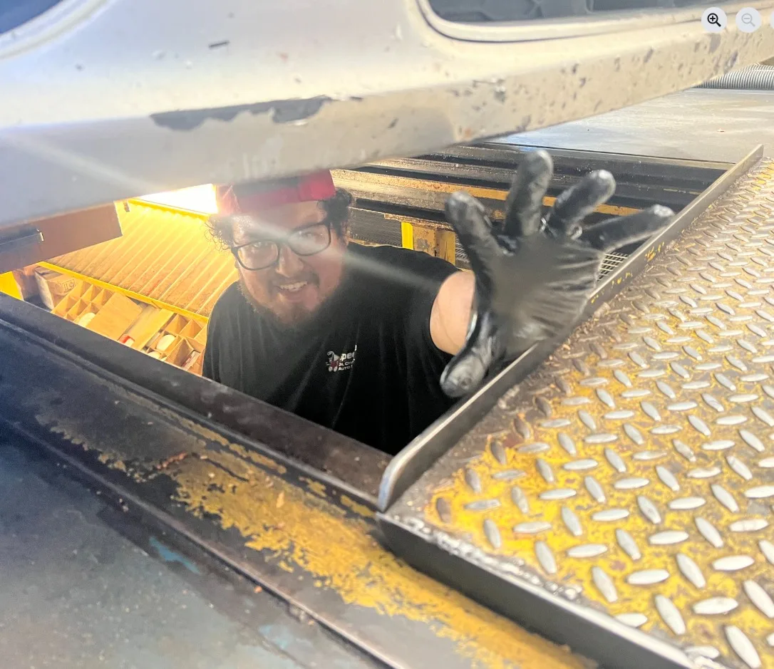 A man reaches into a truck's tool storage box.