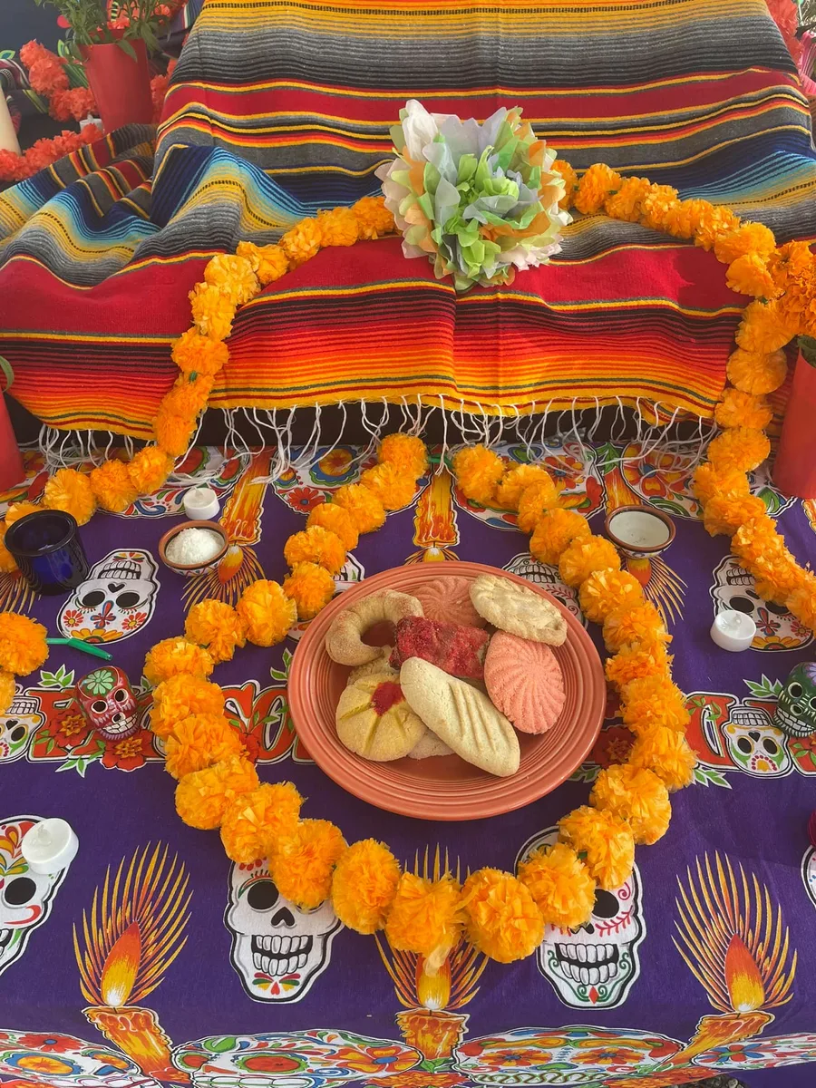 A Day of the Dead altar is decorated with marigold flowers, bread and sugar skulls.