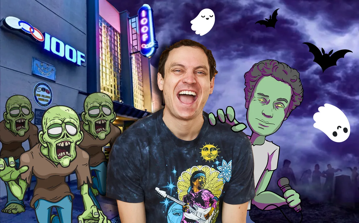 A man laughs in front of a zombie mural and the Odd Fellows sign downtown at night.