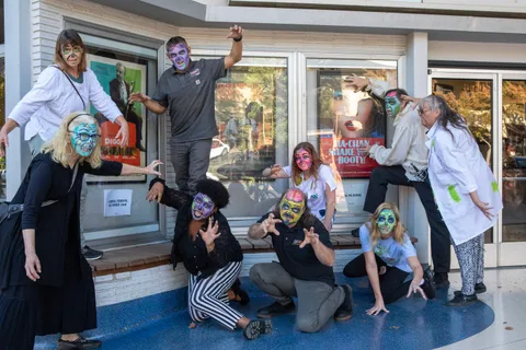 A second pose outside the Varsity Theatre, zombies on the terrazzo and perched on the window ledge beside the poster cases.